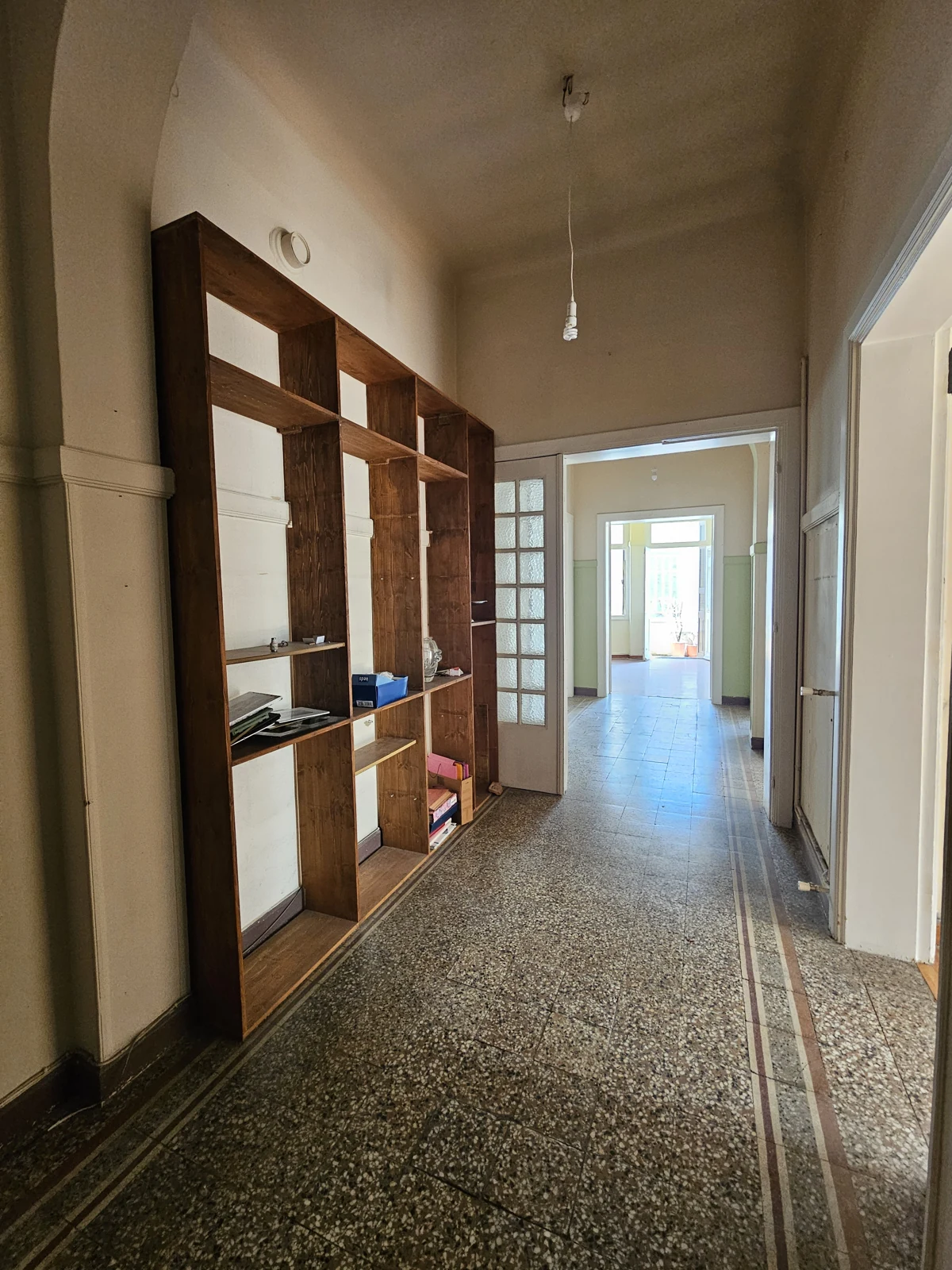 Second floor, current condition — entrance corridor with built-in shelving
